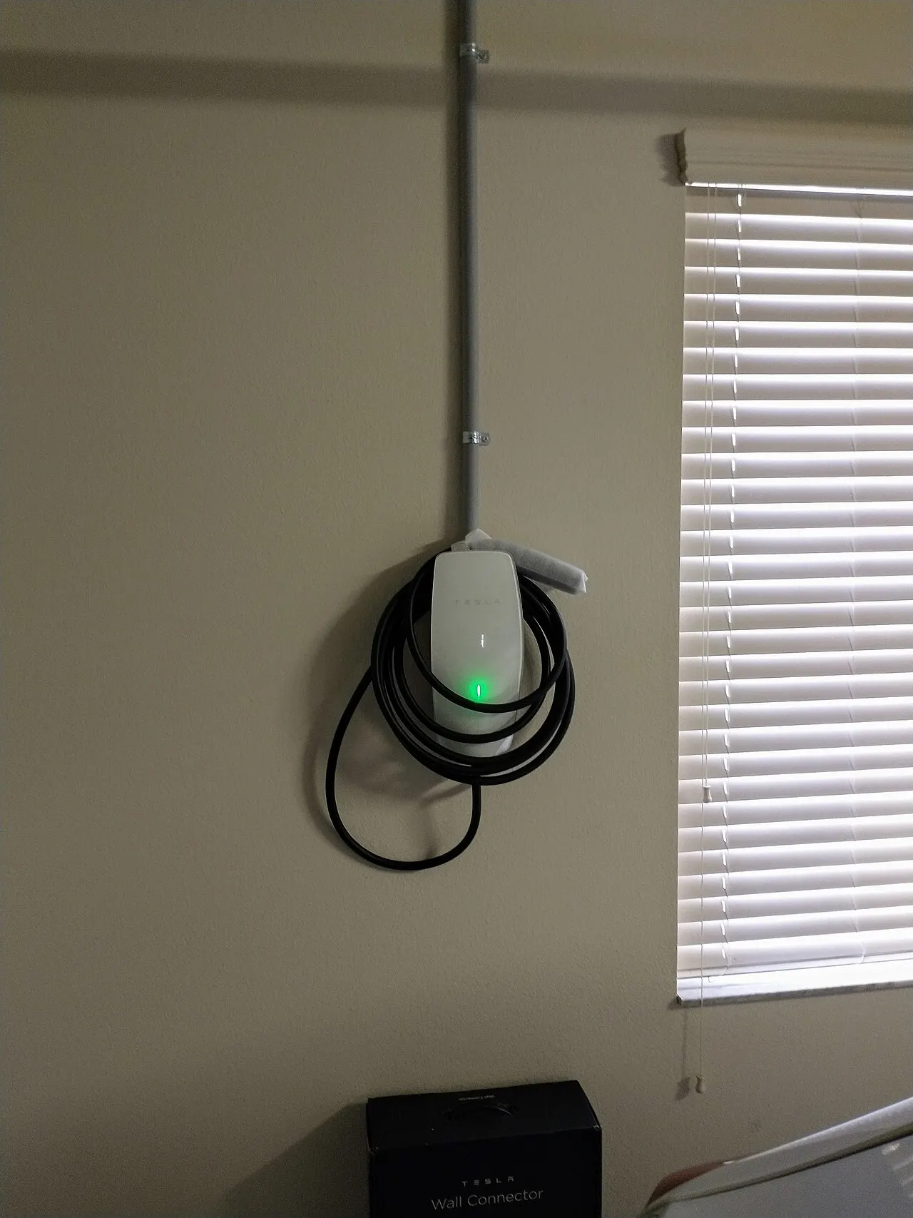 Wall mounted EV charger with cable installed in a garage