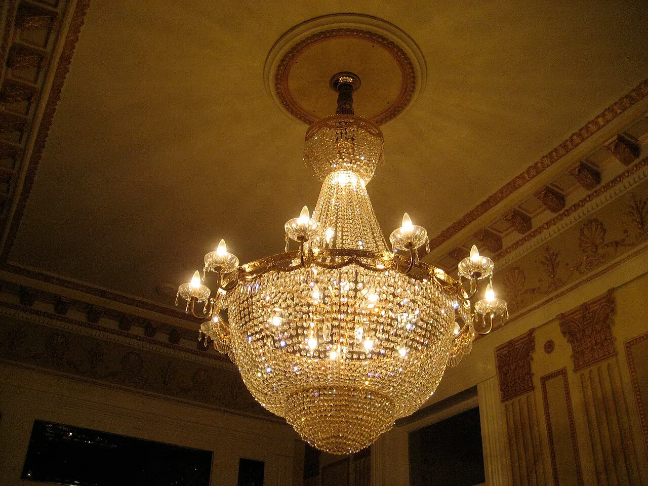 Crystal chandelier lit in a high-ceilinged New Orleans room